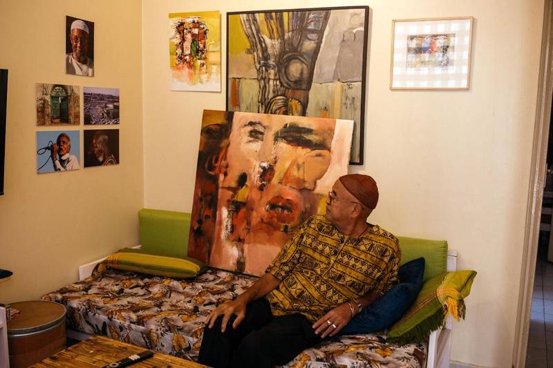 Issam Hafiez in his sitting room in Nairobi, crowded with his work and printed pictures of his friends.