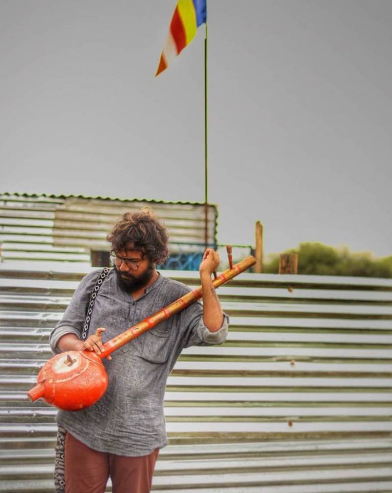 Omey Anand tuning ektara (one-stringed instrument) while shooting for his documentary Kadubai